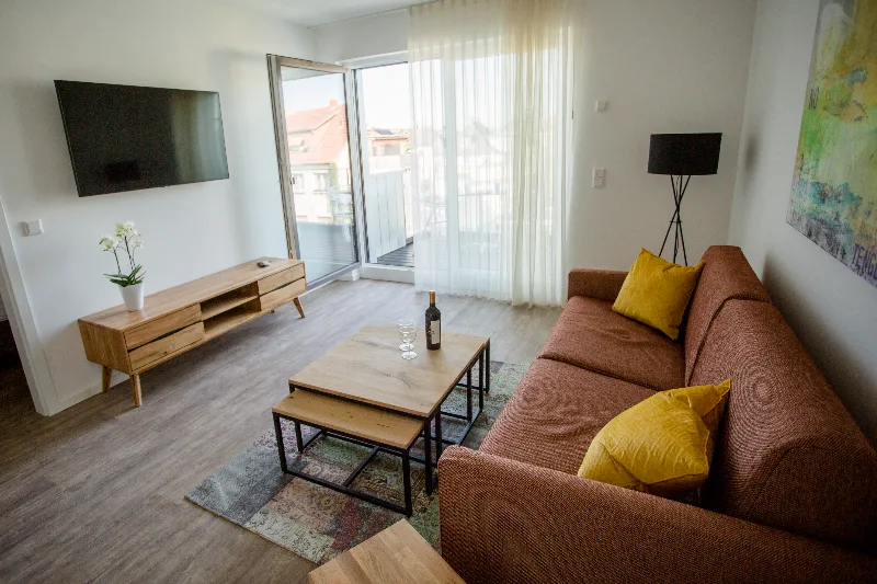 Apartment X-Large 56 m² – Wohnbereich mit Sofa, Smart-TV und Balkonzugang | Boardinghouse Obertshausen