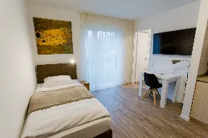 Studio – Schlafbereich mit Einzelbett und Schreibtisch | Boardinghouse Obertshausen