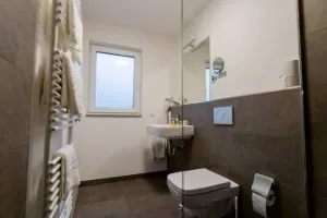 Studio – Badezimmer mit Waschtisch und Handtuchheizkörper | Boardinghouse Obertshausen