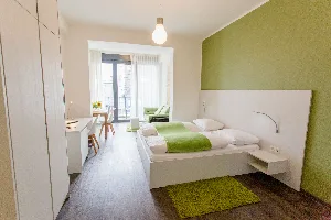Apartment Large – Schlafbereich mit Arbeitsplatz und Blick zum Balkon | Boardinghouse Offenbach