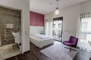 Studio – Schlafbereich mit Balkon und Sessel | Boardinghouse Offenbach